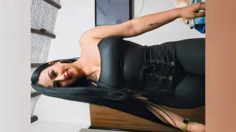 ValentinaJaramilloo poses in a tight black lace-up bodysuit, showing off her long black hair and slim waist.