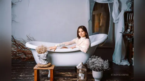 StasyScorpio — StasyScorpio sits in a white bathtub wearing a white lace long-sleeve top.