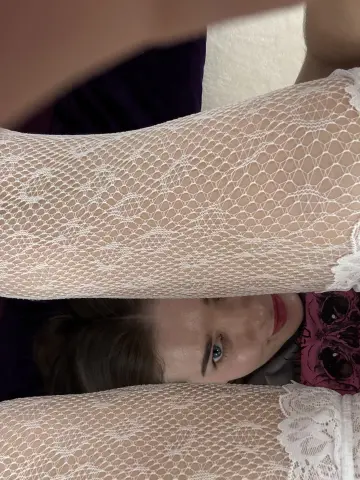 Close-up of a woman wearing a delicate white lace long-sleeve top with a romantic, soft aesthetic.