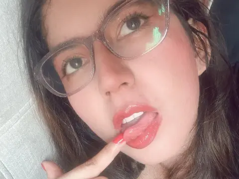 Zharid_Parker wearing glasses and looking at the camera while sticking her tongue out.