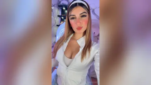 Young woman in a white zip-up jacket and headband posing with a soft glow in a modern indoor setting.