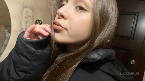 LucileVerlin — LucileVerlin poses in a black puffer jacket with her long brown hair framing her face.