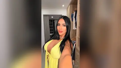 Beautiful woman in a yellow sundress posing in a modern minimalist room with a bright, elegant mood.