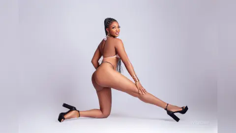 IvyBerry poses on her knees against a white background, wearing a white string bikini that shows off her bare buttocks and smooth skin.