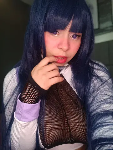 Cosplayer with long blue hair and purple eyes wearing a black mesh top in a soft, dreamy mood.