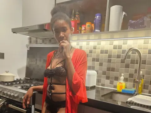 sashapanthera poses in a kitchen wearing a red robe and black lace lingerie.