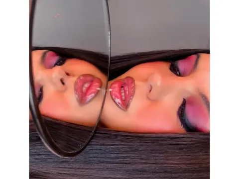 PrincesssAnisia — PrincesssAnisia looks into a mirror with pink eyeshadow and wet, glossy lips.