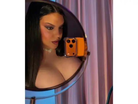 PrincesssAnisia — PrincesssAnisia takes a mirror selfie, showing her long dark hair, makeup, and cleavage while wearing a sparkly choker.