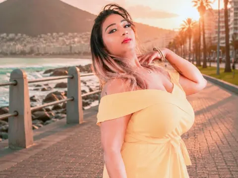 princesSsandy — princesSsandy poses in a yellow dress on a seaside boardwalk during sunset.