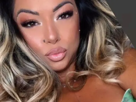 kitttty4play — Glamorous woman with blonde highlighted hair and glowing makeup looking into the camera.