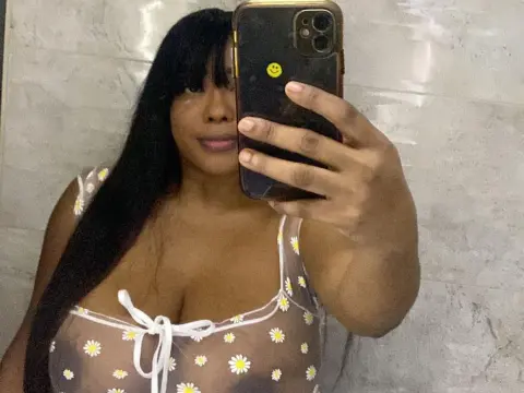 Tyfaniebony — Young woman in a white daisy print sundress taking a mirror selfie in a bright bathroom.
