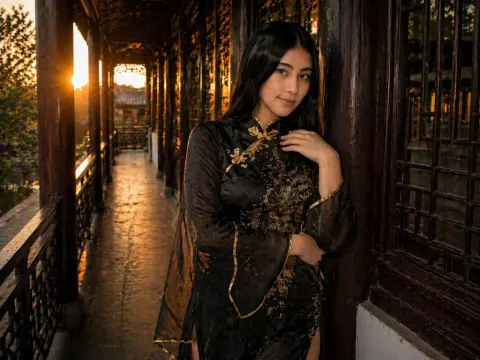 Young woman in elegant black traditional Chinese hanfu standing on a wooden balcony at sunset.