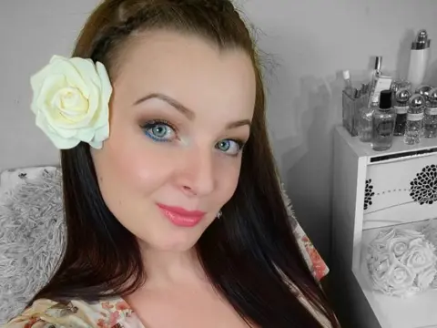 Single_Beauty — Smiling woman with a white rose in her hair and floral outfit in a bright beauty room setting.