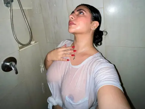 LyssaSunnyy stands in a shower wearing a wet, sheer white t-shirt that shows her nipples.