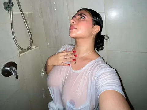 LyssaSunnyy — LyssaSunnyy poses in a white t-shirt under running shower water, showing her wet skin and wet hair.