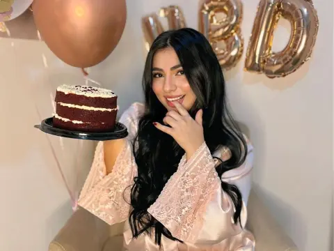LyssaSunnyy — LyssaSunnyy smiles while holding a small red velvet cake in a pink lace robe next to a copper balloon.
