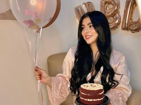 LyssaSunnyy — LyssaSunnyy smiles while holding a white balloon and a red velvet cake, wearing a light pink lace robe.