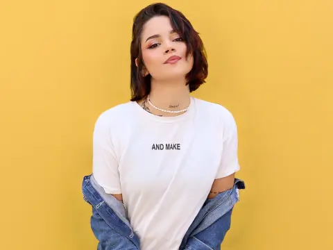 LaurenWard — Young woman in a white graphic t-shirt and denim jacket smiling against a bright yellow background.