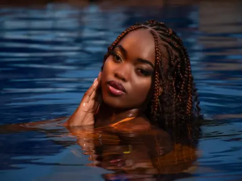 Beautiful Black woman with braided hair relaxing in a blue swimming pool during a serene summer evening.
