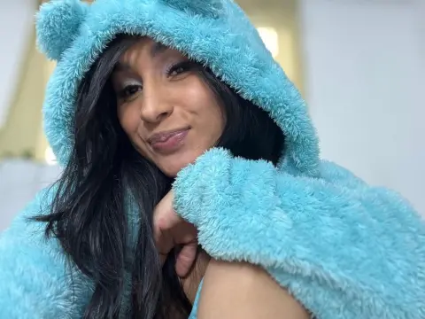 Smiling young woman in a cozy light blue fuzzy hooded sweatshirt relaxing indoors.