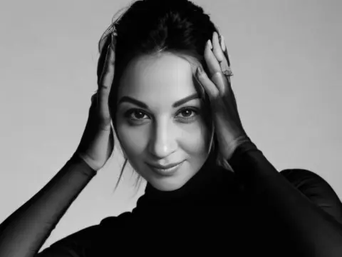 Kethlyne — Elegant woman in a black turtleneck posing for a moody black and white studio portrait.