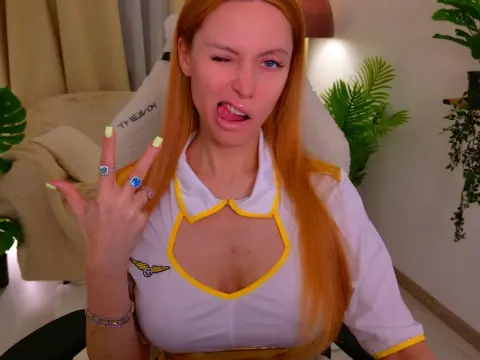 LoveCall — Playful redhead woman in a white collared outfit making a peace sign in a bright indoor setting.