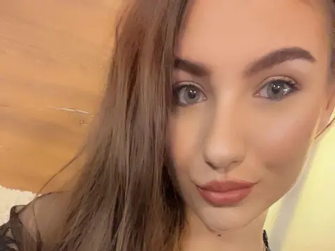 NorraJoice — NorraJoice looks into the camera with long brown hair and light eyes in a close-up selfie.