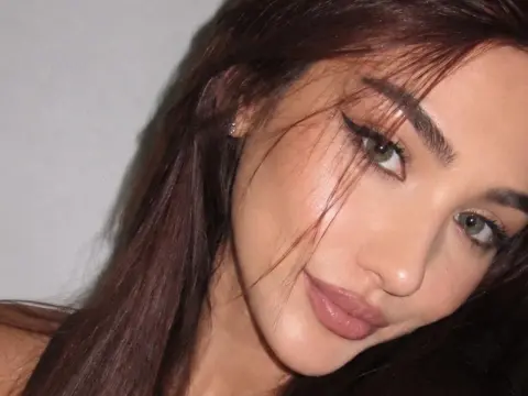 NorraJoice — NorraJoice looks into the camera with long brown hair and winged eyeliner.