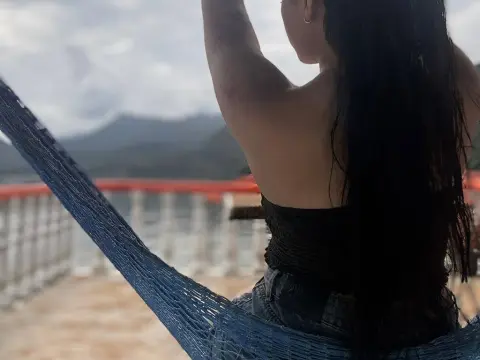 Alison_Tatcher — Woman in black top relaxing in a blue hammock overlooking misty mountains and a lake.