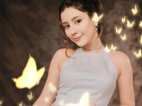 SweetTulip — Smiling woman in a white halter top surrounded by glowing magical butterflies in a dreamy studio setting.