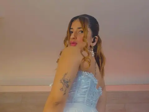 LaraJones — LaraJones poses in a white lace corset, looking over her shoulder with her wavy hair down.