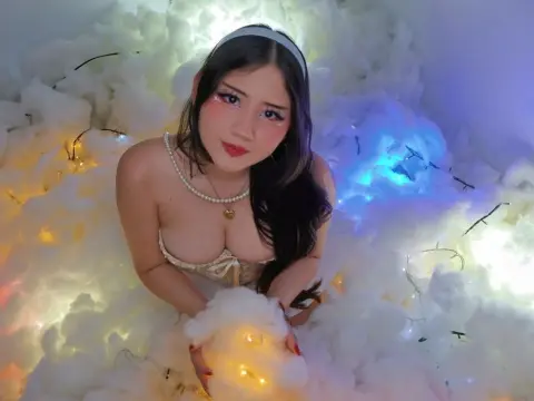 Dreamy portrait of a woman in a white headband and pearl necklace sitting amidst glowing cotton clouds.