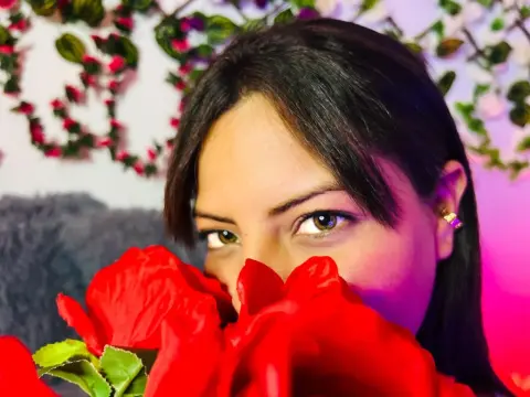 miacollinsx — miacollinsx hiding her face behind a large red rose, showing her eyes and dark hair against a floral background.