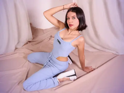 HoneyLia — Young woman in light blue ribbed loungewear sitting on beige fabric in a soft, minimalist studio setting.