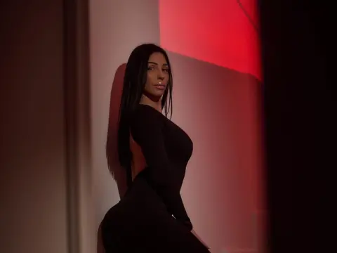 Elegant woman in a sleek black dress posing against a dramatic red and white studio background.