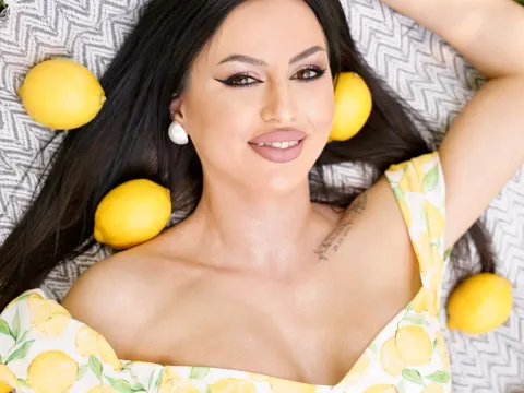 CamileOwnes — CamileOwnes lies on a patterned towel wearing a yellow lemon print sundress with lemons scattered around her hair.