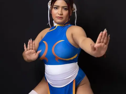 Chun-Li cosplayer in a blue and white martial arts outfit posing confidently against a black background.