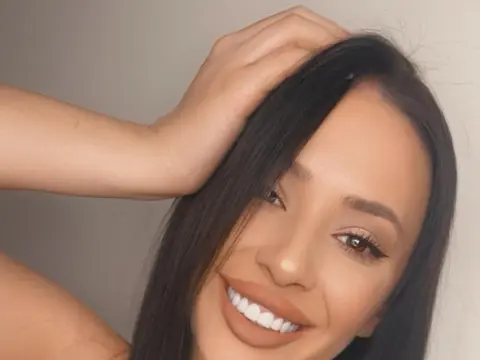 JessicaSoul — Smiling young woman with long dark hair and natural makeup posing against a neutral background.