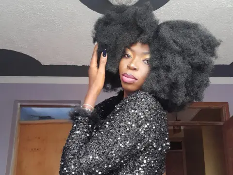 Darkmajestiy — Stylish Black woman with voluminous afro hairstyle wearing a sparkling black sequin outfit indoors.