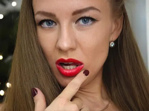 TakeMeFuckMe — Close-up of a woman with red lipstick and long blonde hair posing with a playful expression.