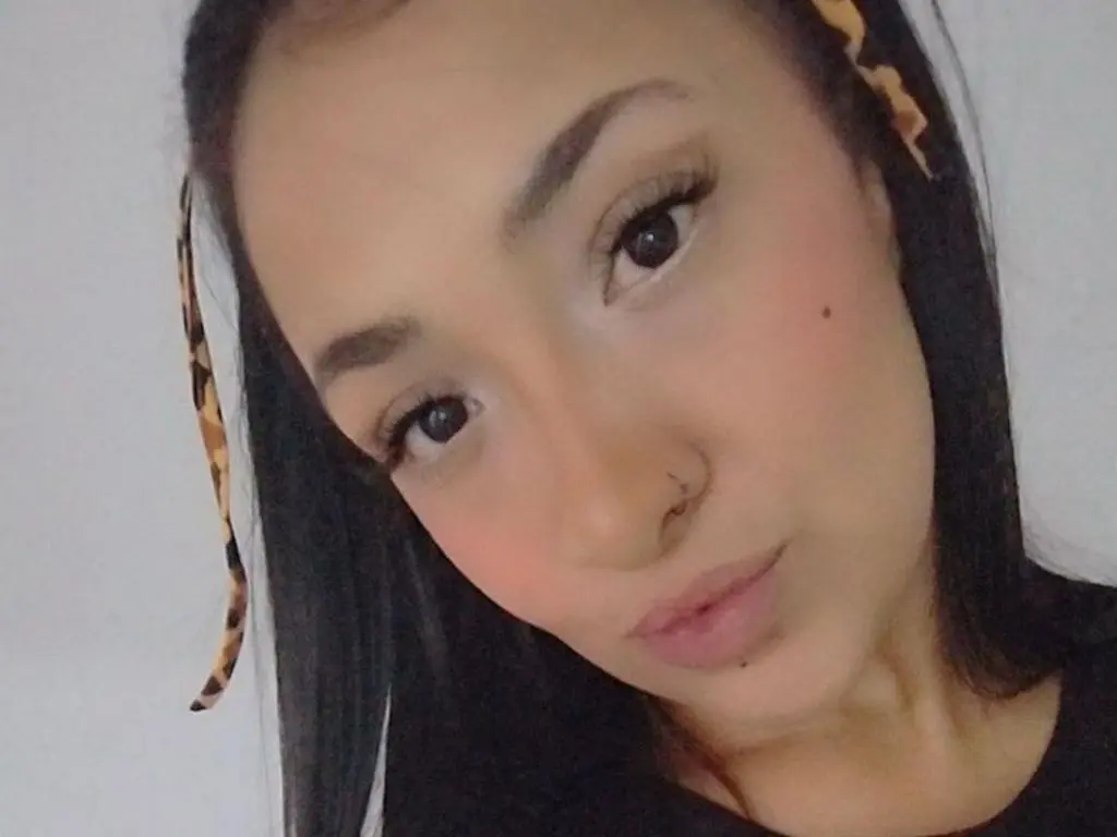 Sabri30 looks directly at the camera with long dark hair and a nose piercing, wearing a black top against a plain white background.