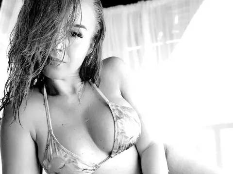 ToxiC_Game — ToxiC_Game poses in a floral bikini top with wet hair, looking at the camera in a bright room.