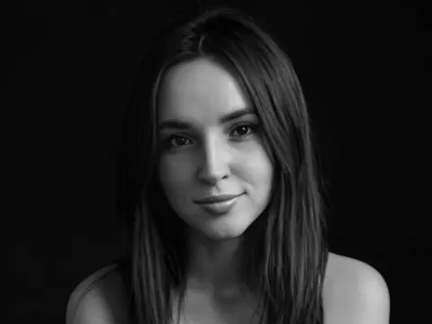 AmelyAngelx — Black and white portrait of a young woman with long hair looking serene against a dark background.