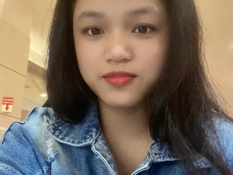 BabySweet18x — BabySweet18x wearing a blue denim jacket with long, dark hair and red lipstick, looking directly at the camera.