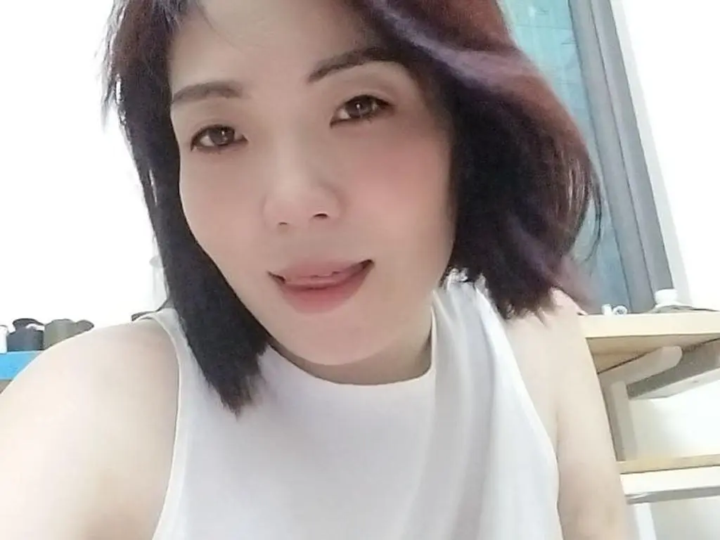 Mymy83 looks at the camera with a slight smile, wearing a white sleeveless top with her dark hair styled down.