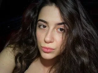 18Brooke looks into the camera with long wavy dark hair in a close-up shot.