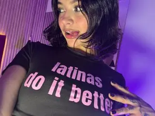 AbbieRhondes wears a black t-shirt that says 'latinas do it better' while posing with her dark hair down.