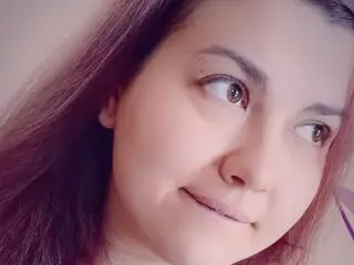 AlexaSwetie looks toward the side with her long dark hair framing her face in a close-up shot.