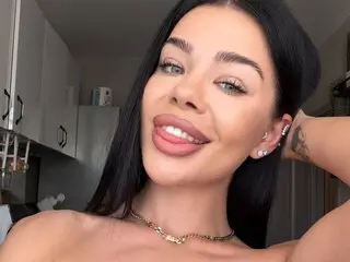 Alexaheyess smiles while looking at the camera, showing her teeth and long black hair.