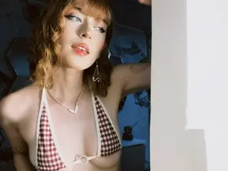Alice_Valentine poses in a red and white checkered bikini top, showing her cleavage and blonde hair against a dark background.